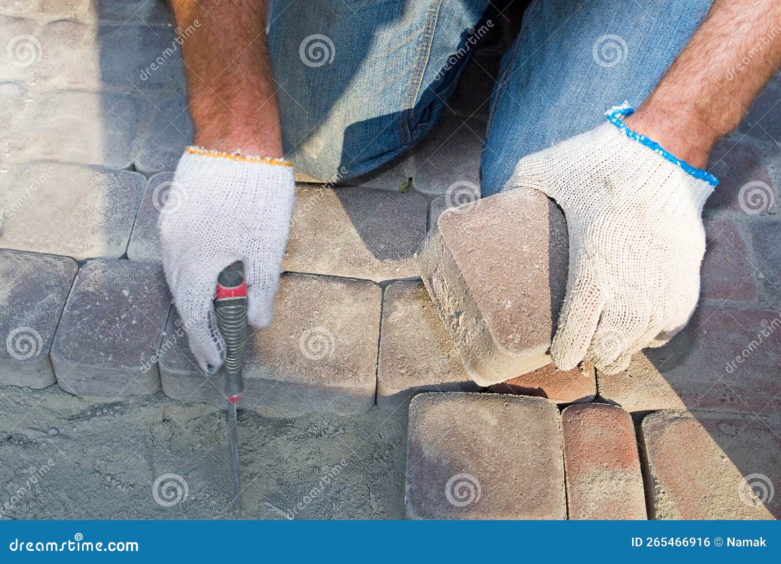 construc worker fixing the pavestone on the roadtion worker installing stone blocks on pavement