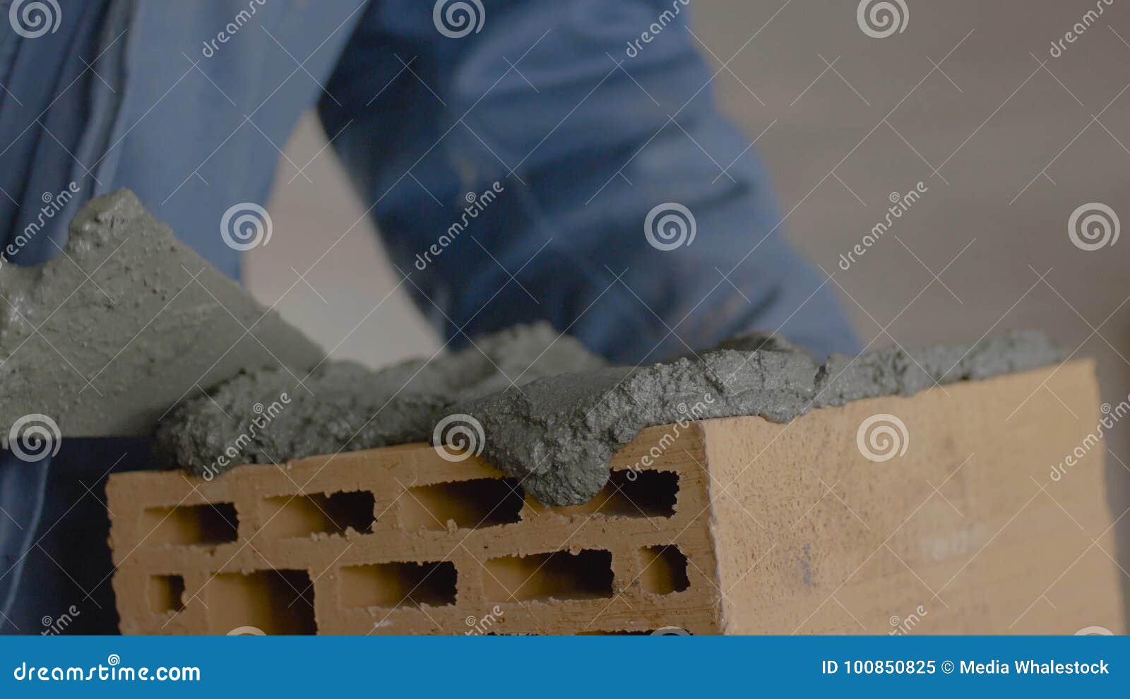 Construction of Brick Wall. Trowel Spreading Cement on Bricks Stock