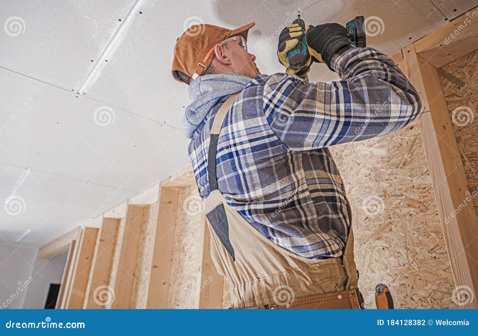 Construction Contractor Attaching Drywall Elements To the House Ceiling