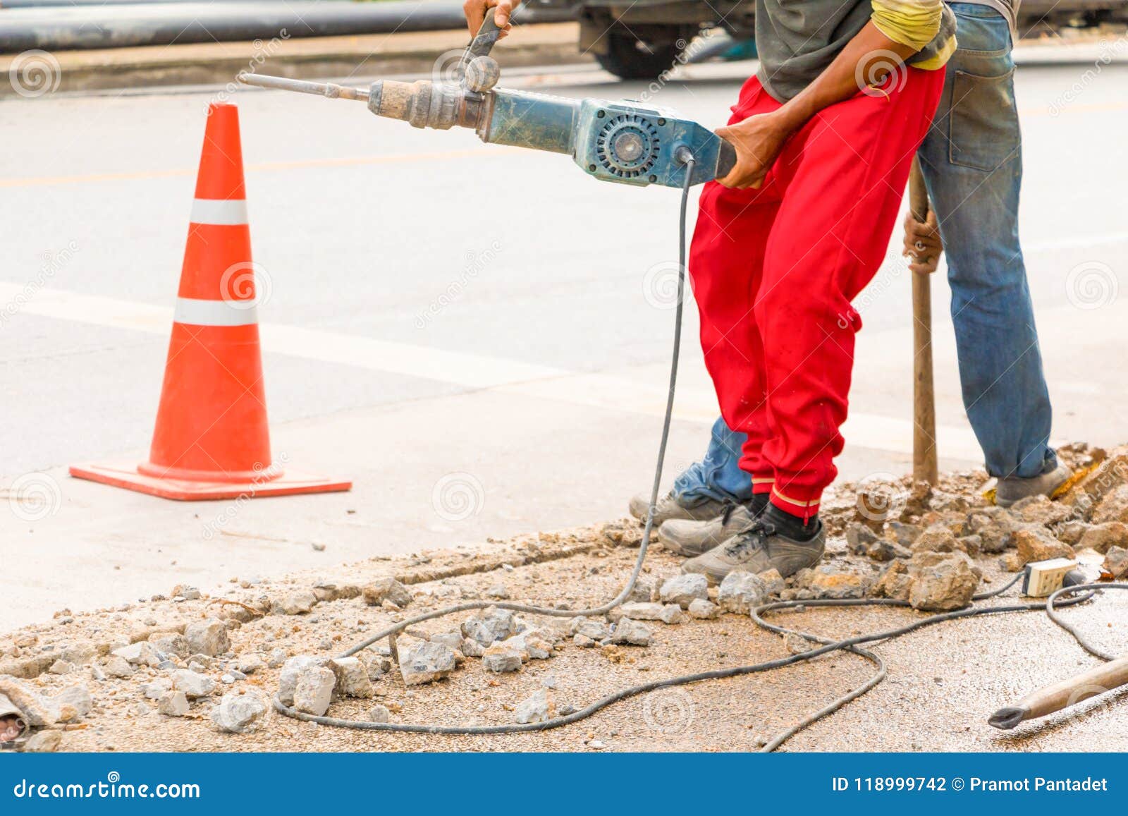 Construction Drilling Repair Worker on Road Surface with Heavy Duty