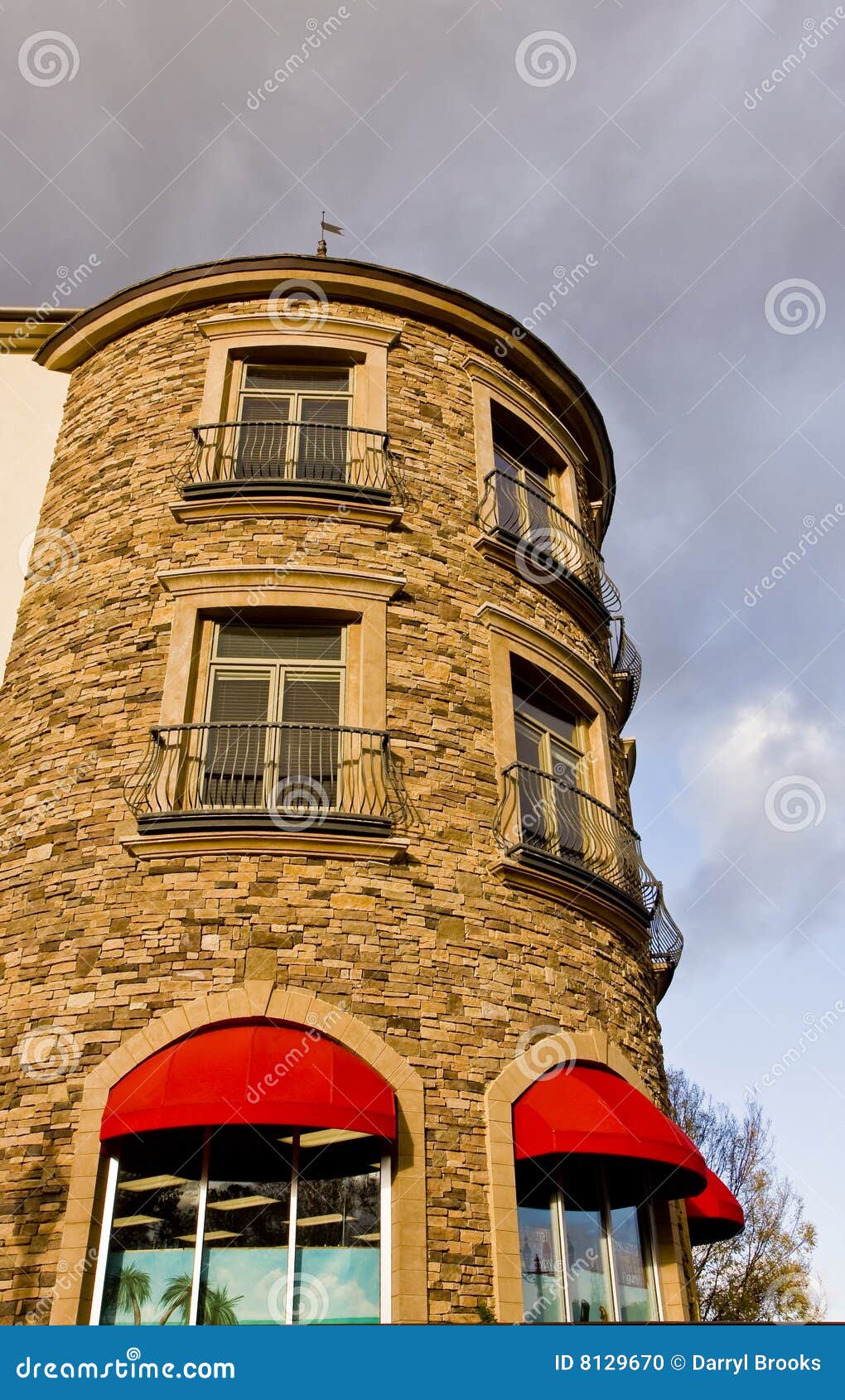 Construction en pierre ronde et tentes rouges. Un mur en pierre incurvé avec des pêches à la traîne de fer et une tente rouge