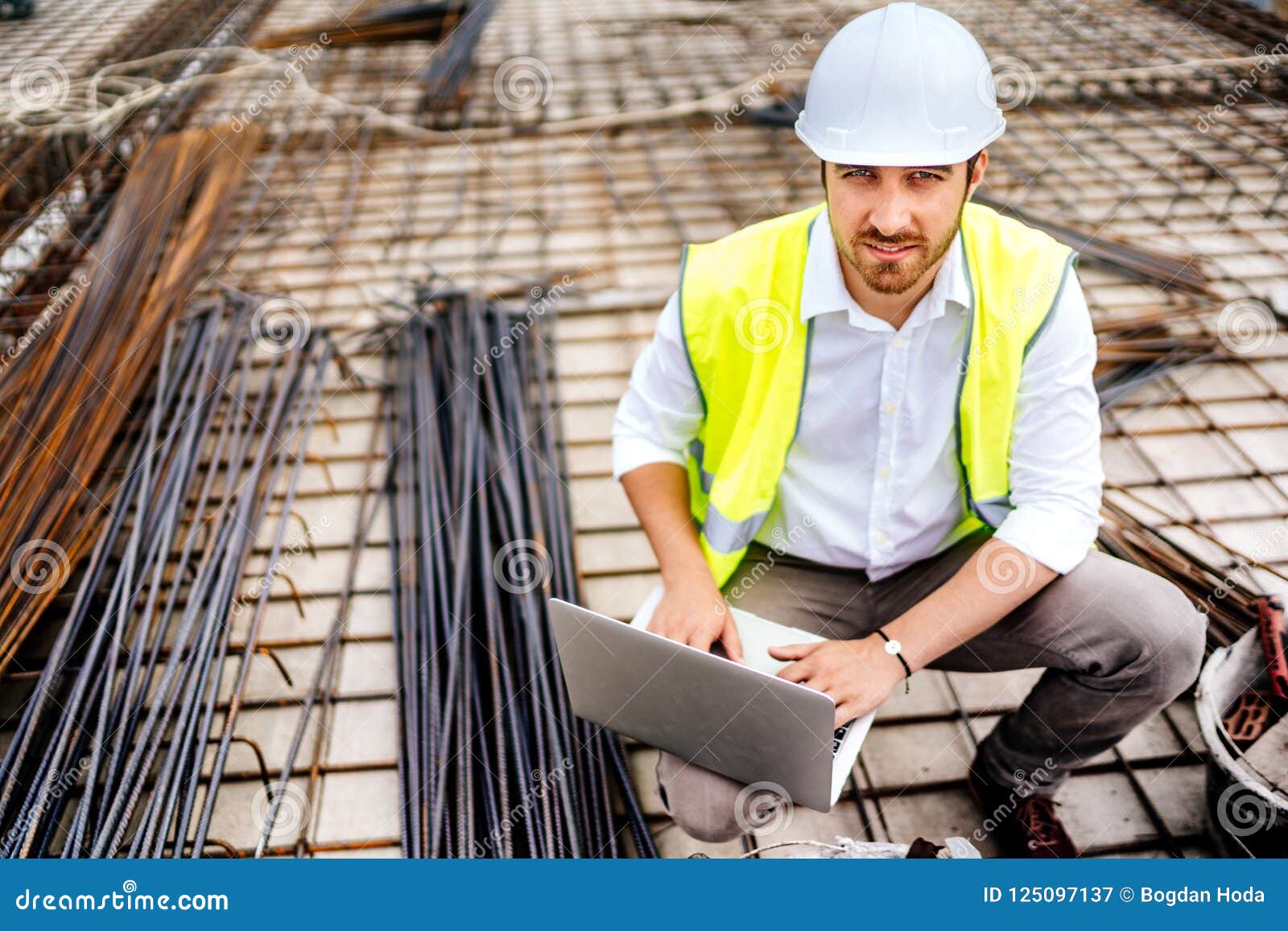 Construction Engineer Working on Laptop, Wearing Safety Equipement and