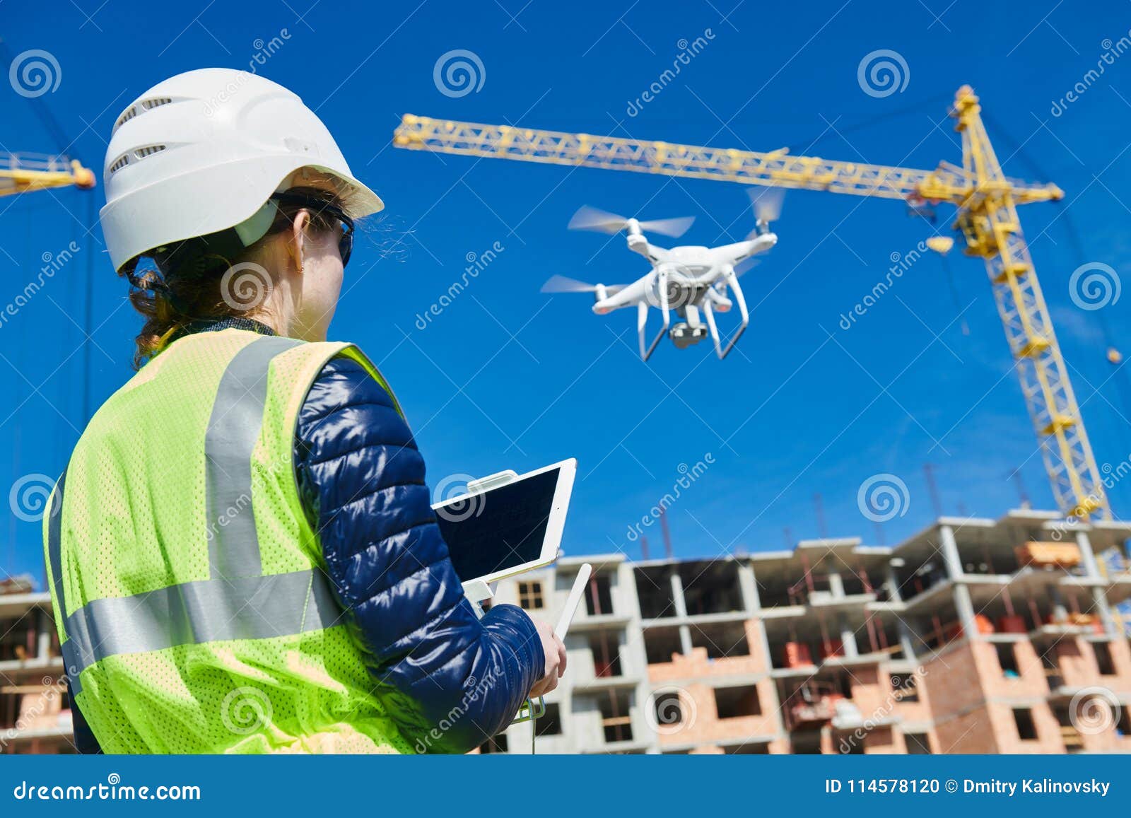 drone inspection. operator inspecting construction building site flying with drone