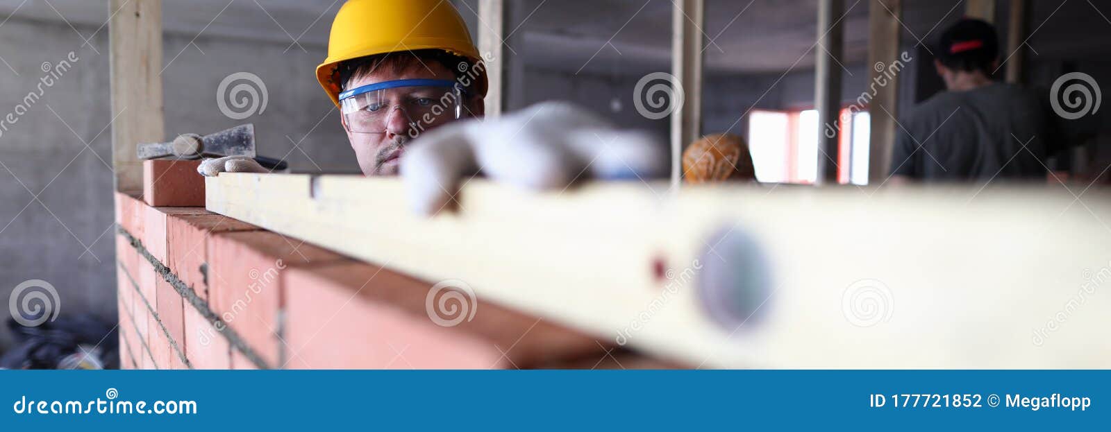 construction guy helmet measures level brickwork