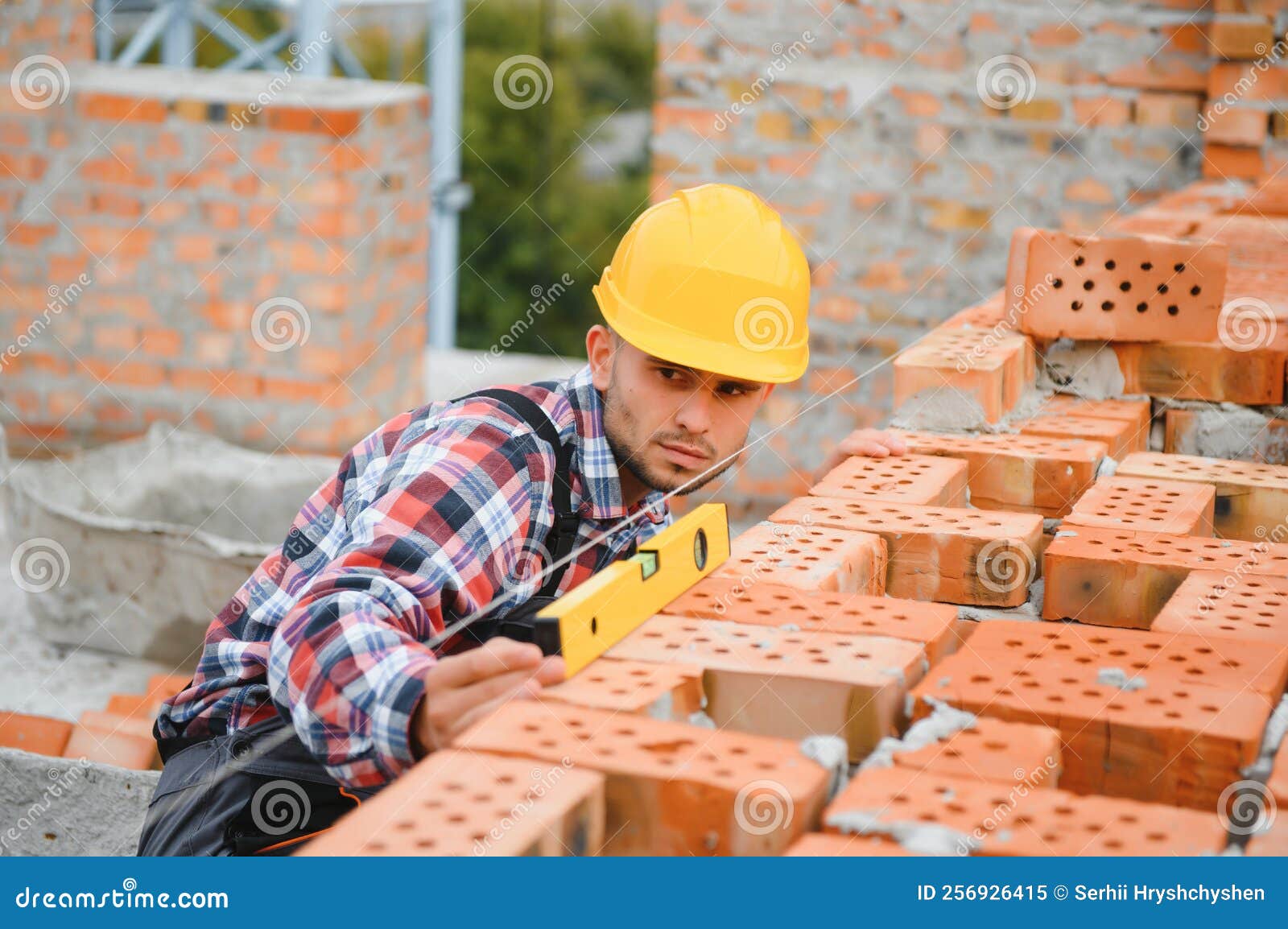 Construction Mason Worker Bricklayer Installing Red Brick with Trowel