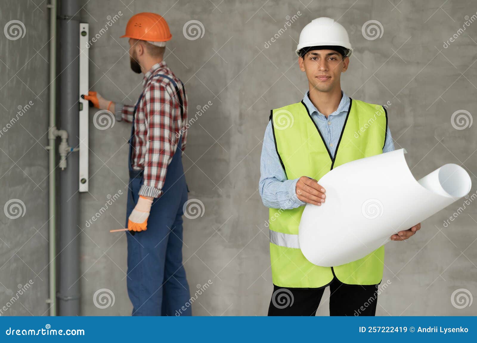 Construction Site Engineer or Architect with Blueprints and Builder