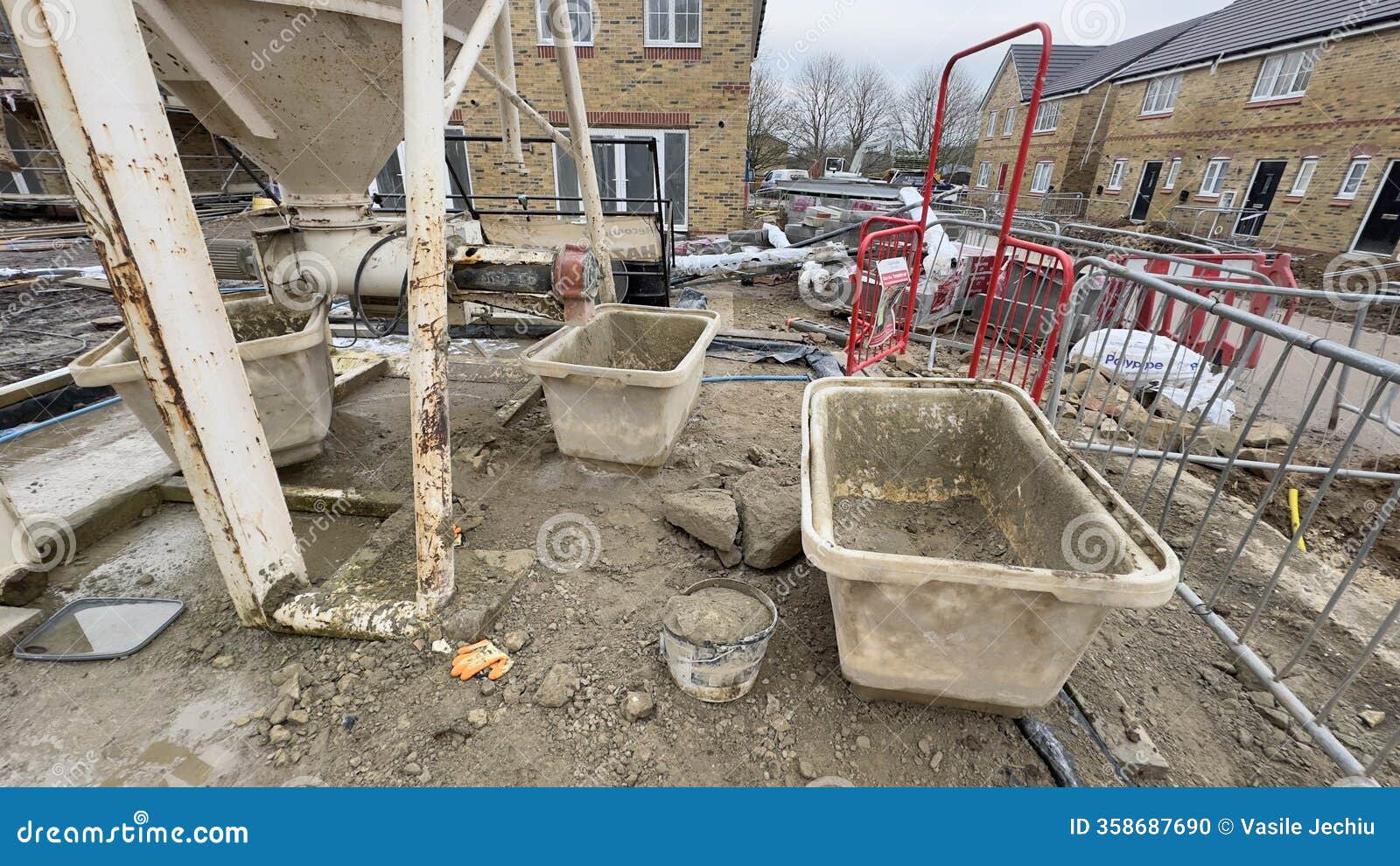construction site with concrete mixer and material bins
