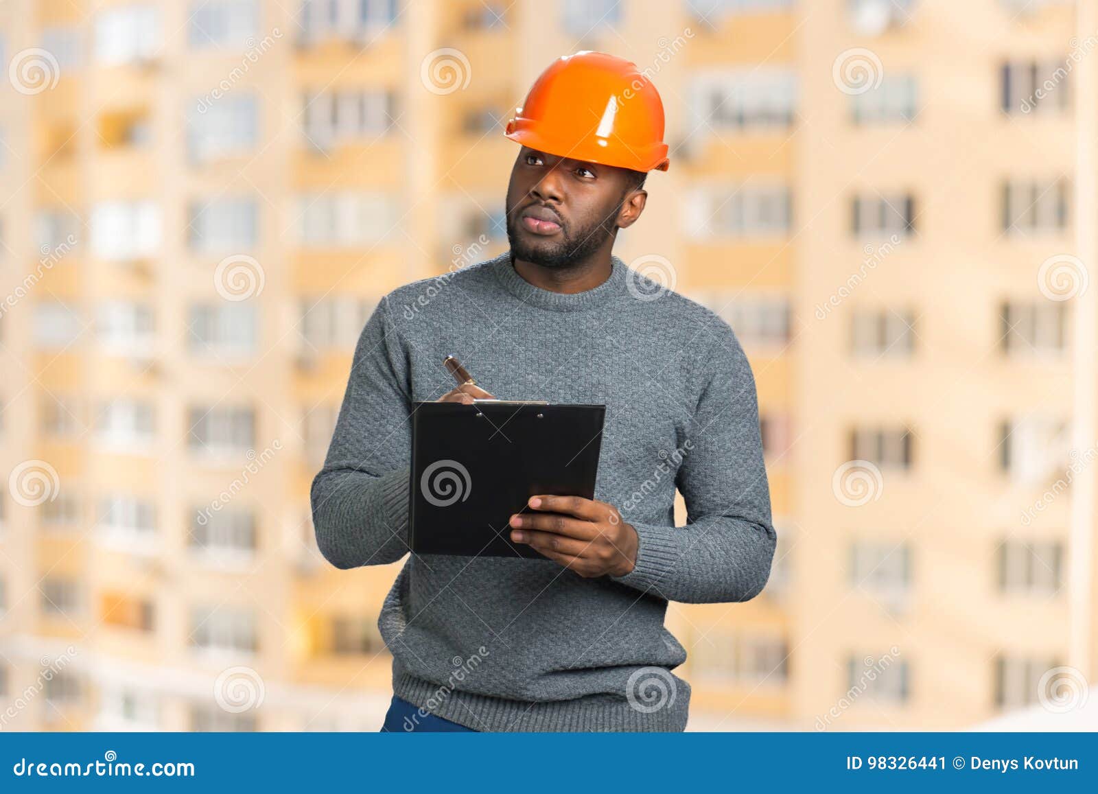 construction supervisor writes on clipboard.