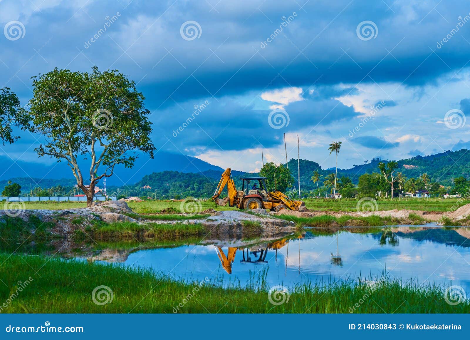 A Construction Tractor Works in a Field on a Tropical Island. Start of