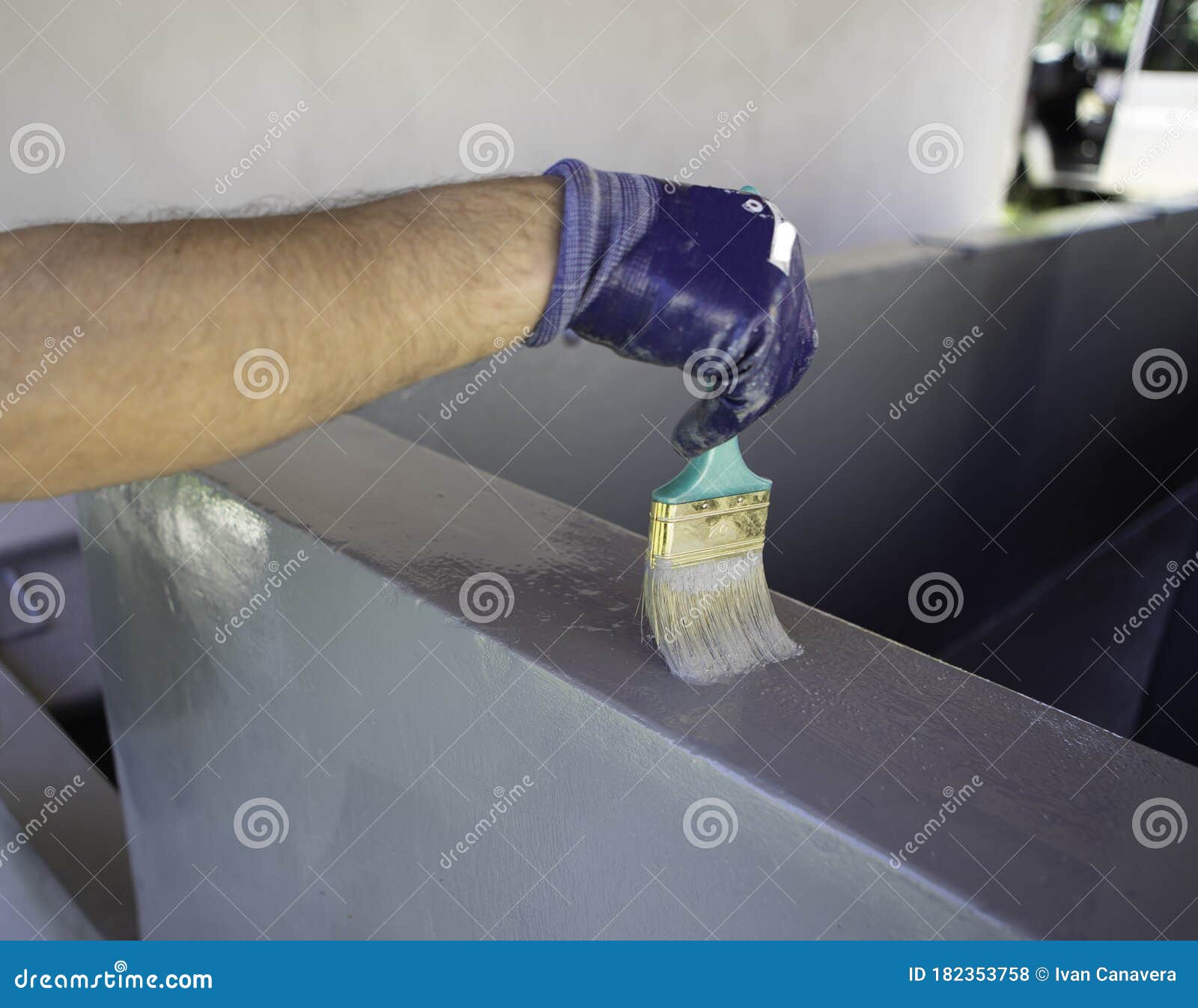 man using a brush to paint a swimming pool