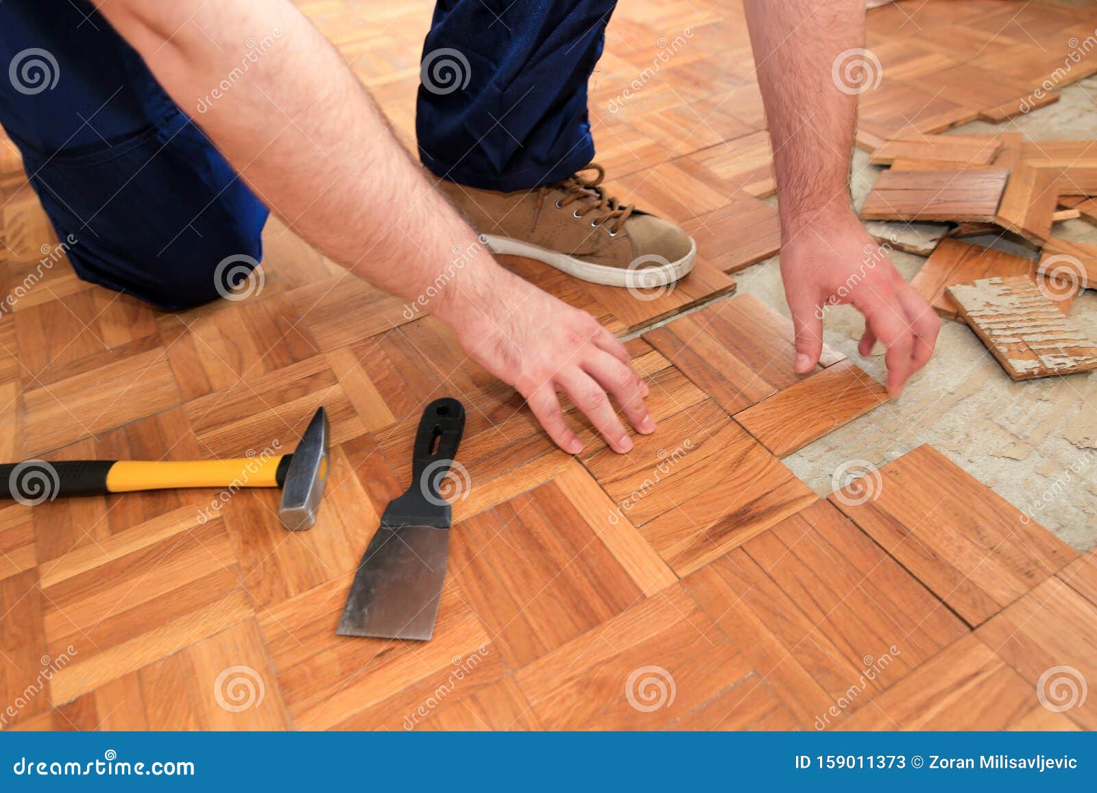 Construction Worker And Handyman Is Removing Old Wooden Parquet