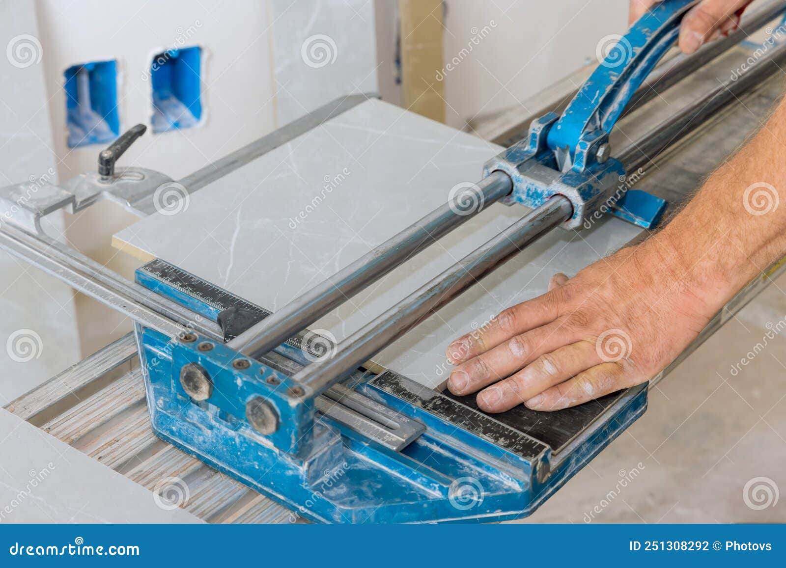 Construction Worker Cuts Ceramic Tile Floors Using Manual Tools