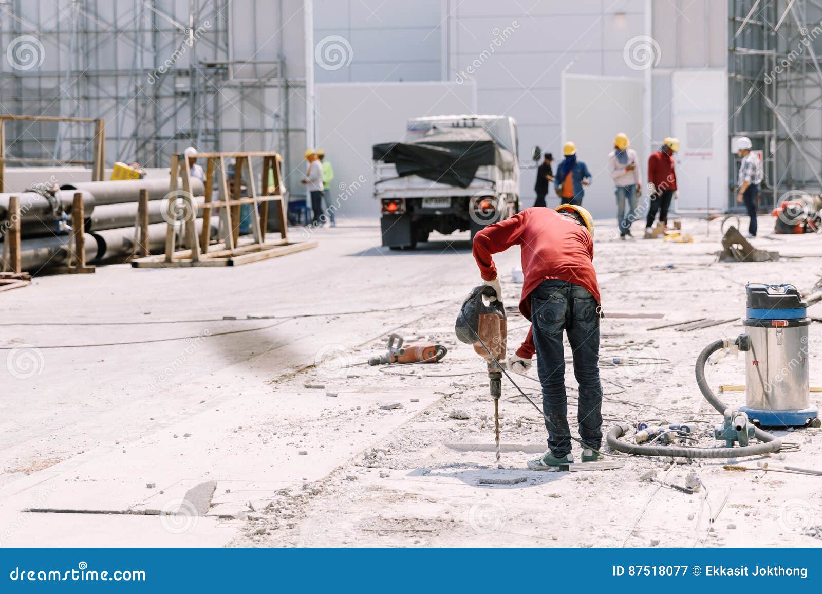 Construction Worker Electric Drill Drilling Concrete Ground in Stock