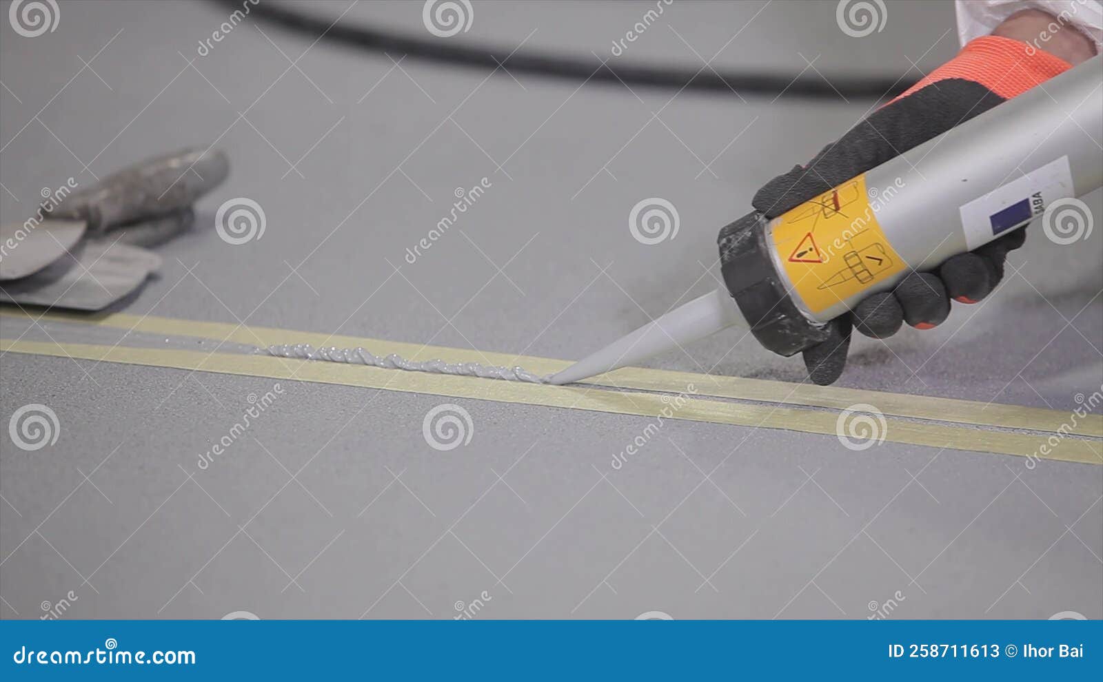 Construction Worker Grouting Seams in Concrete Floor. the Builder