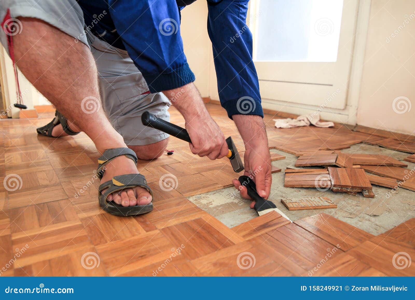 Construction Worker And Handyman Is Removing Old Wooden Parquet