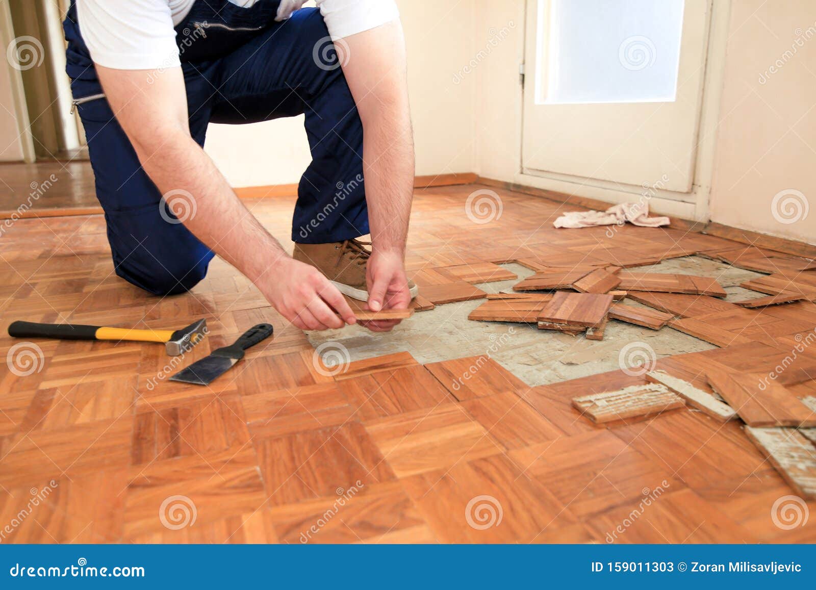 Construction Worker And Handyman Is Removing Old Wooden Parquet