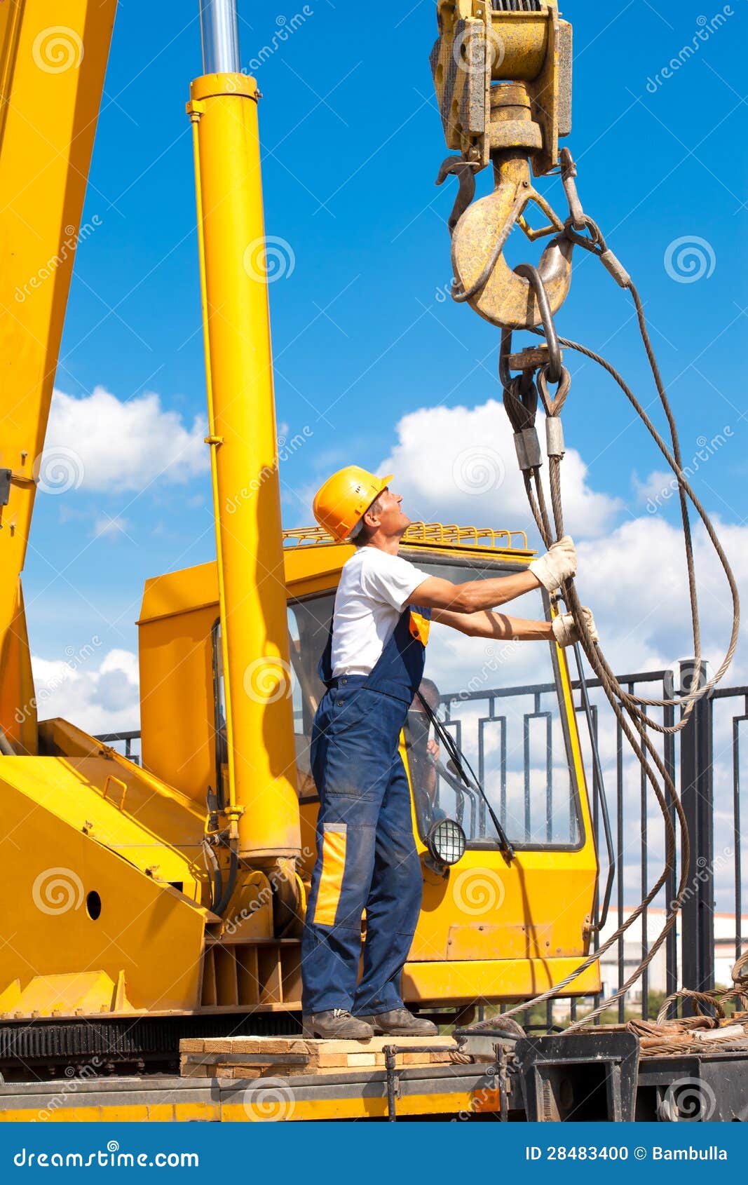construction worker during hoisting works by a mobile crane