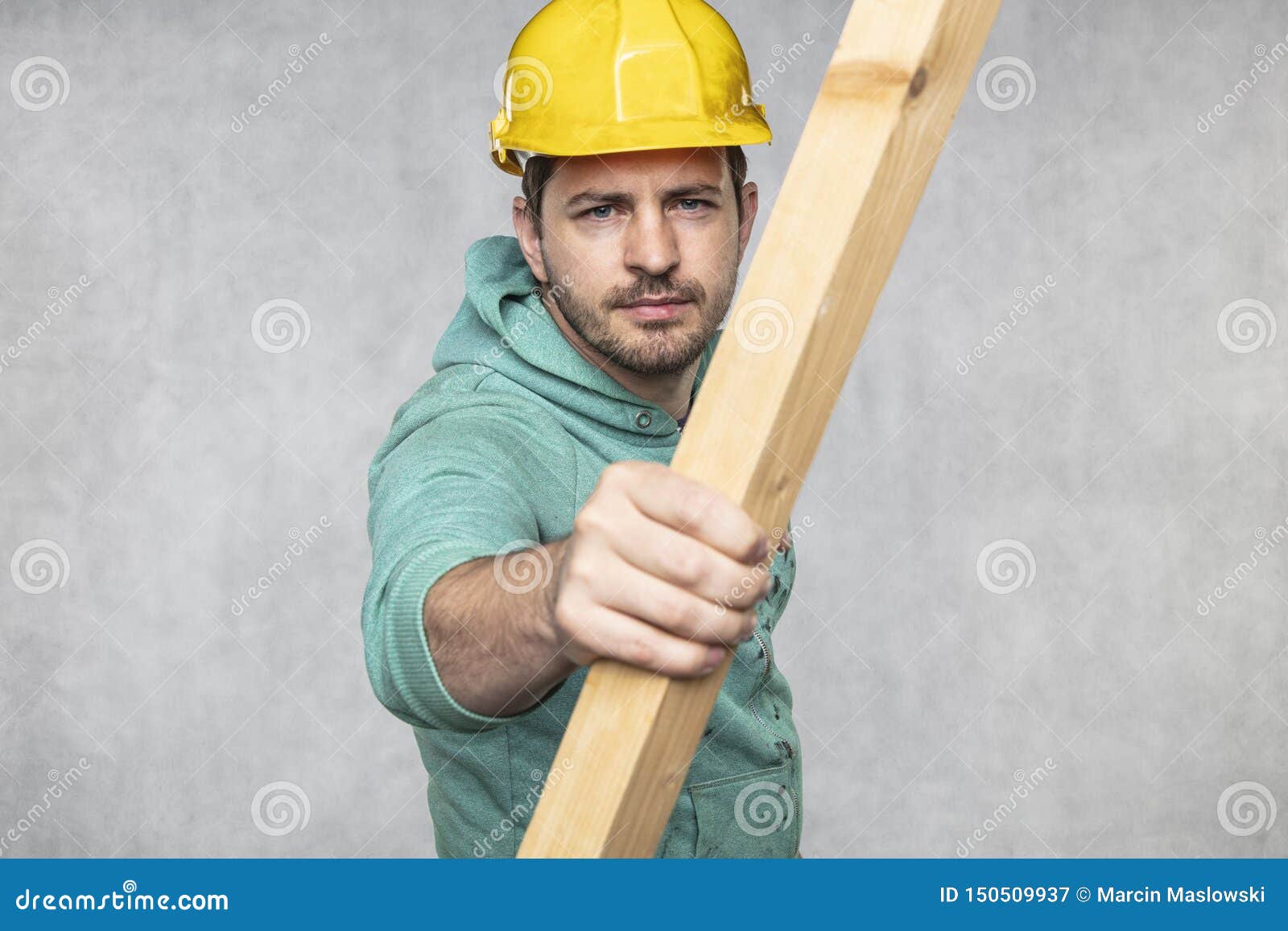 The Construction Worker Holds a Piece of Board in His Hands, the
