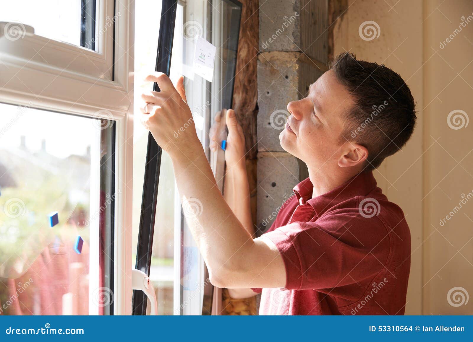 construction worker installing new windows in house