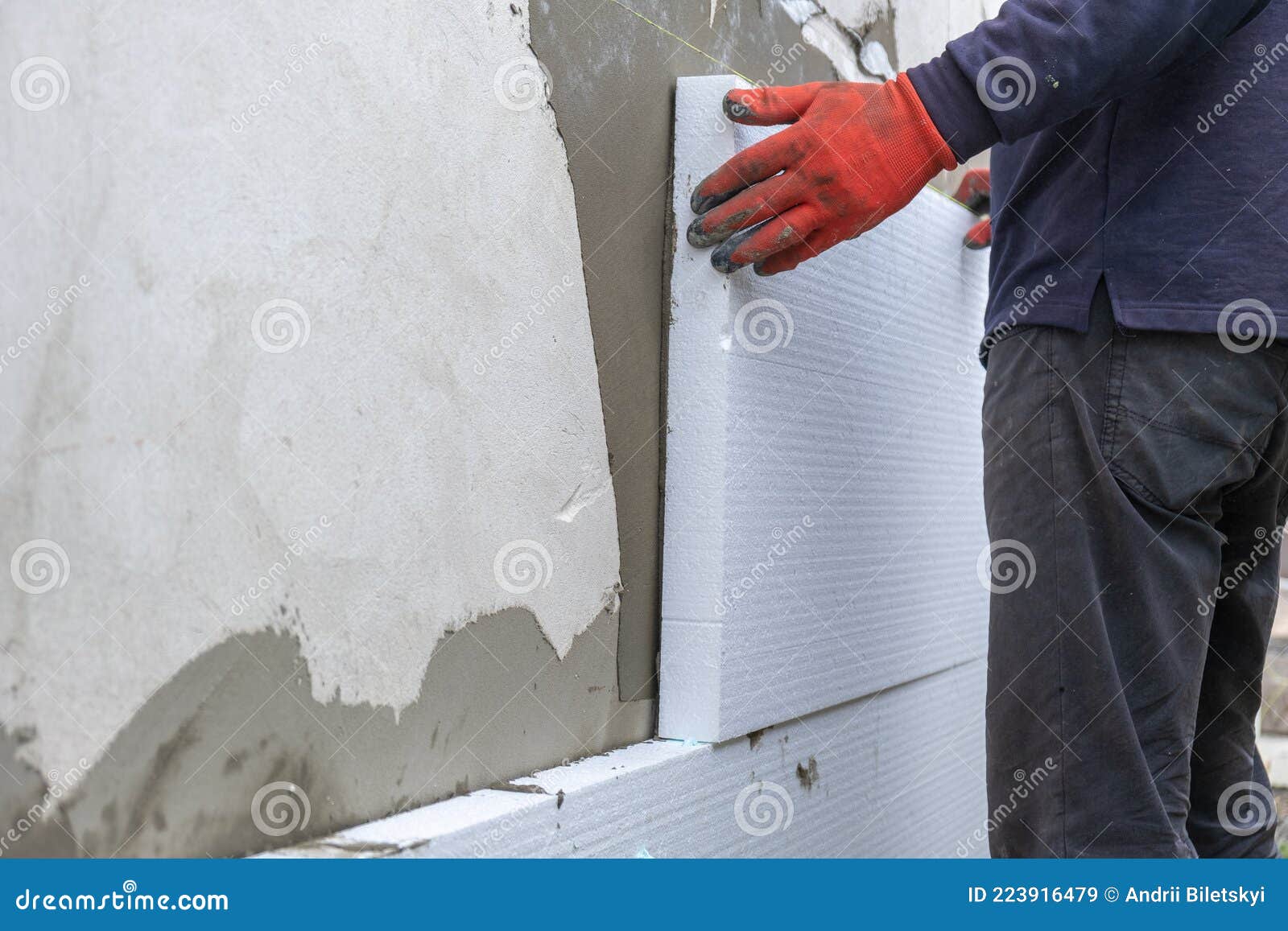 Construction Worker Installing Styrofoam Insulation Sheets on House