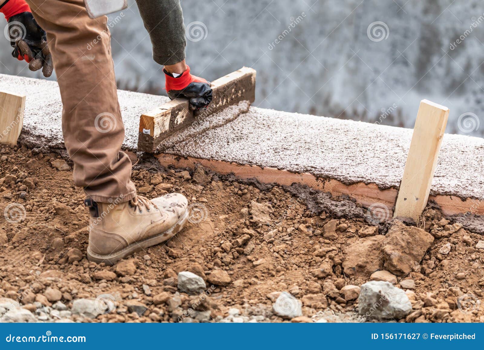 Construction Worker Leveling Wet Cement into Wood Framing Stock Image
