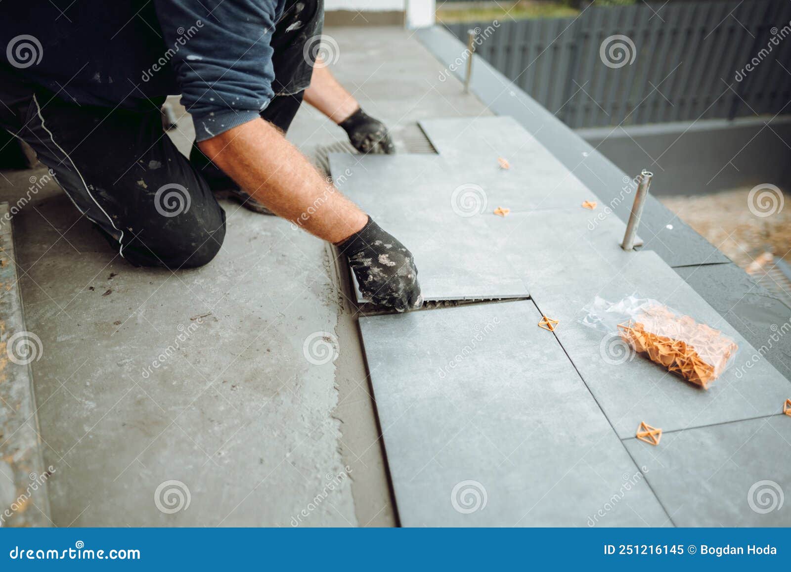 Construction Worker Placing Ceramic Floor Tile in Position Over