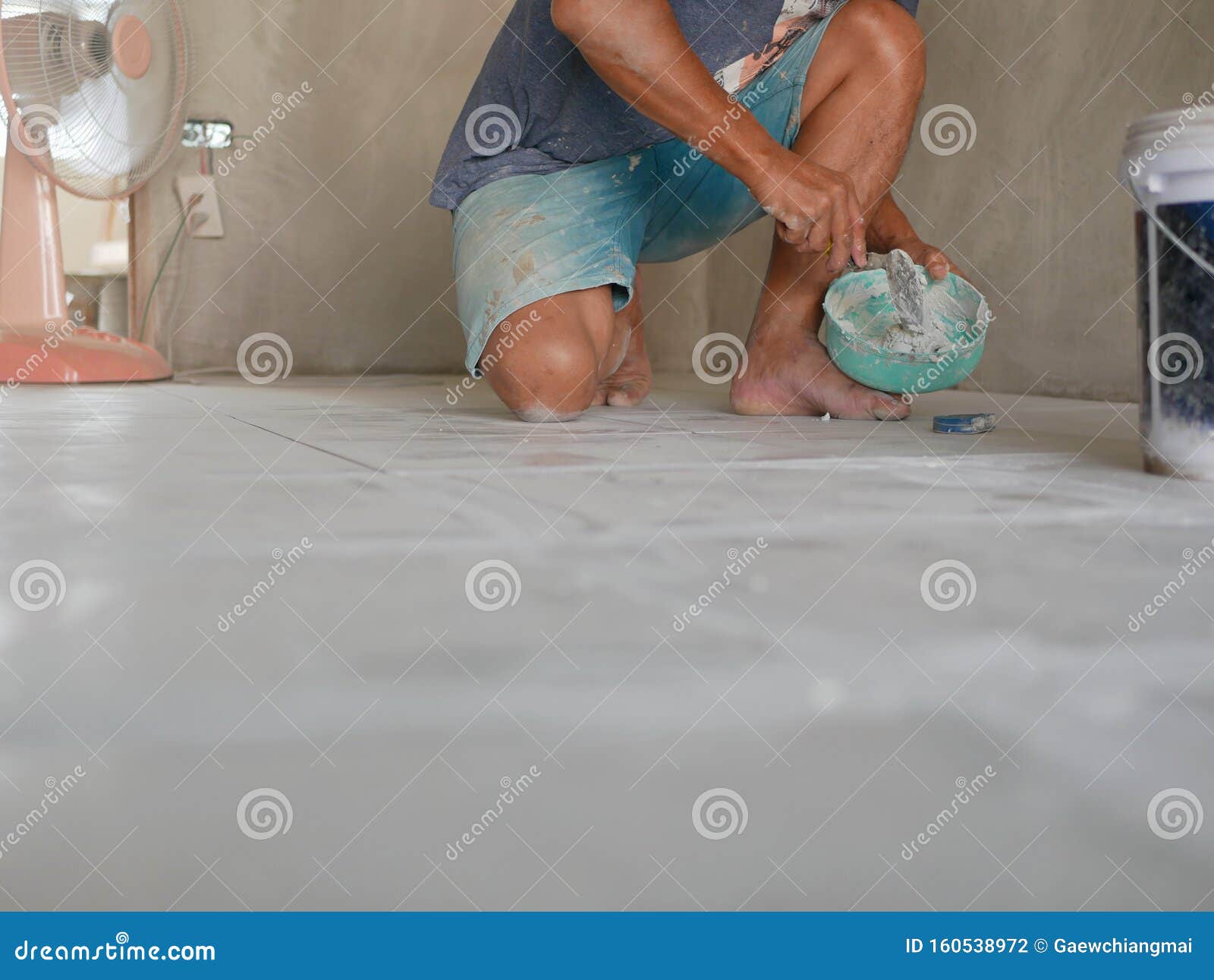 A Construction Worker Preparing Tile Grout Before Appling It On