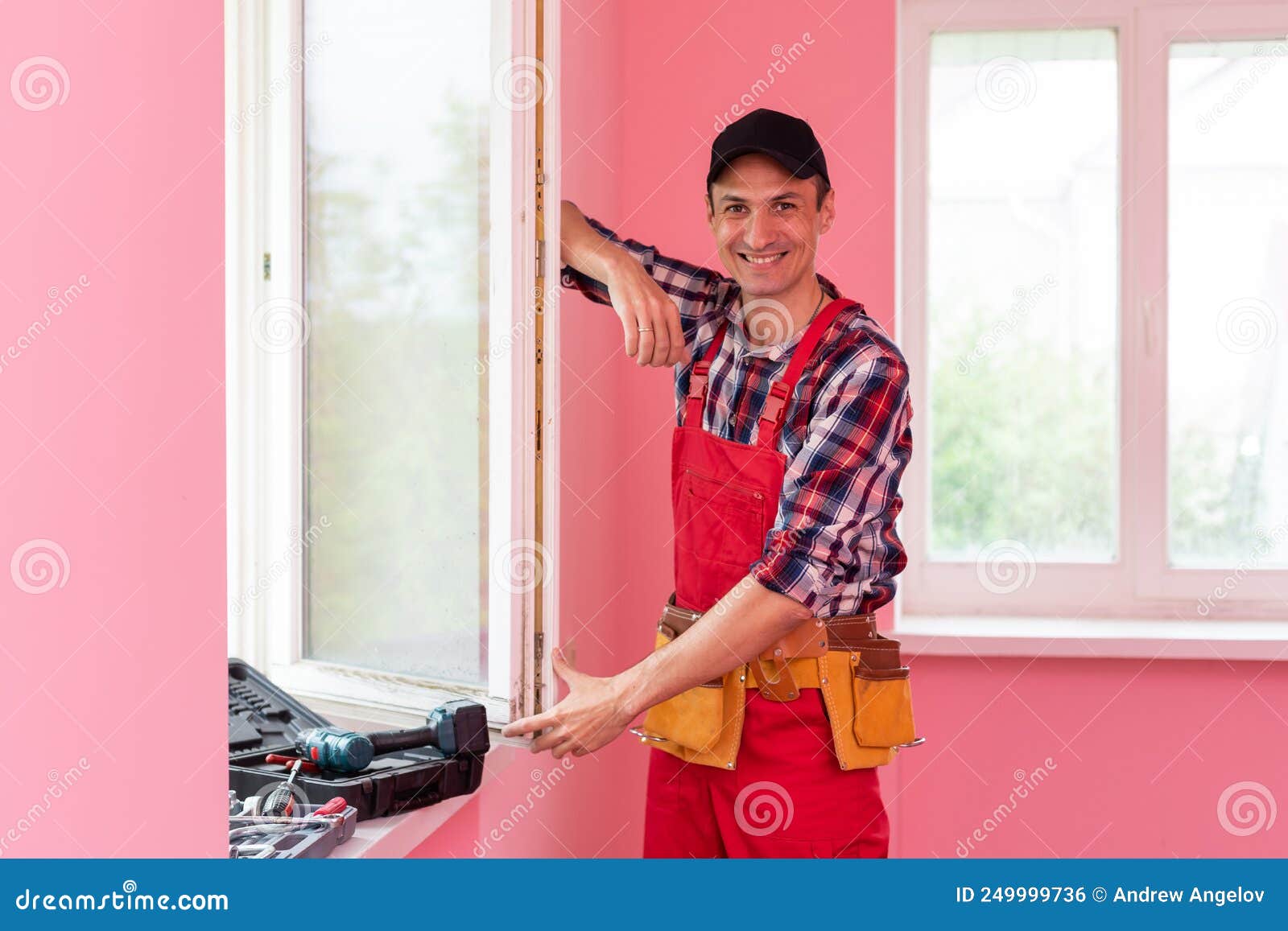 Construction Worker Repairing Plastic Window with Screwdriver Indoors