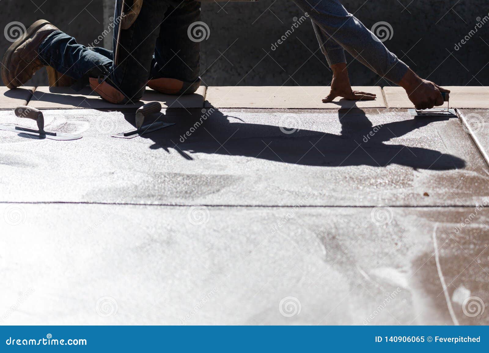 Construction Worker Smoothing Wet Cement with Hand Edger Tool Stock