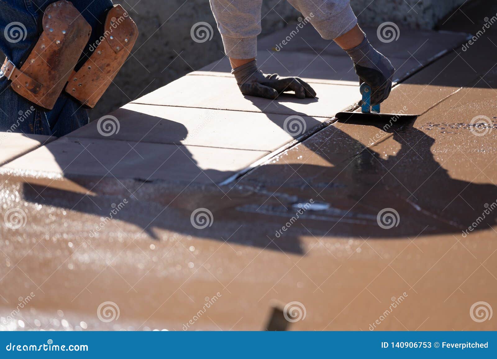 Construction Worker Smoothing Wet Cement with Hand Edger Tool Stock