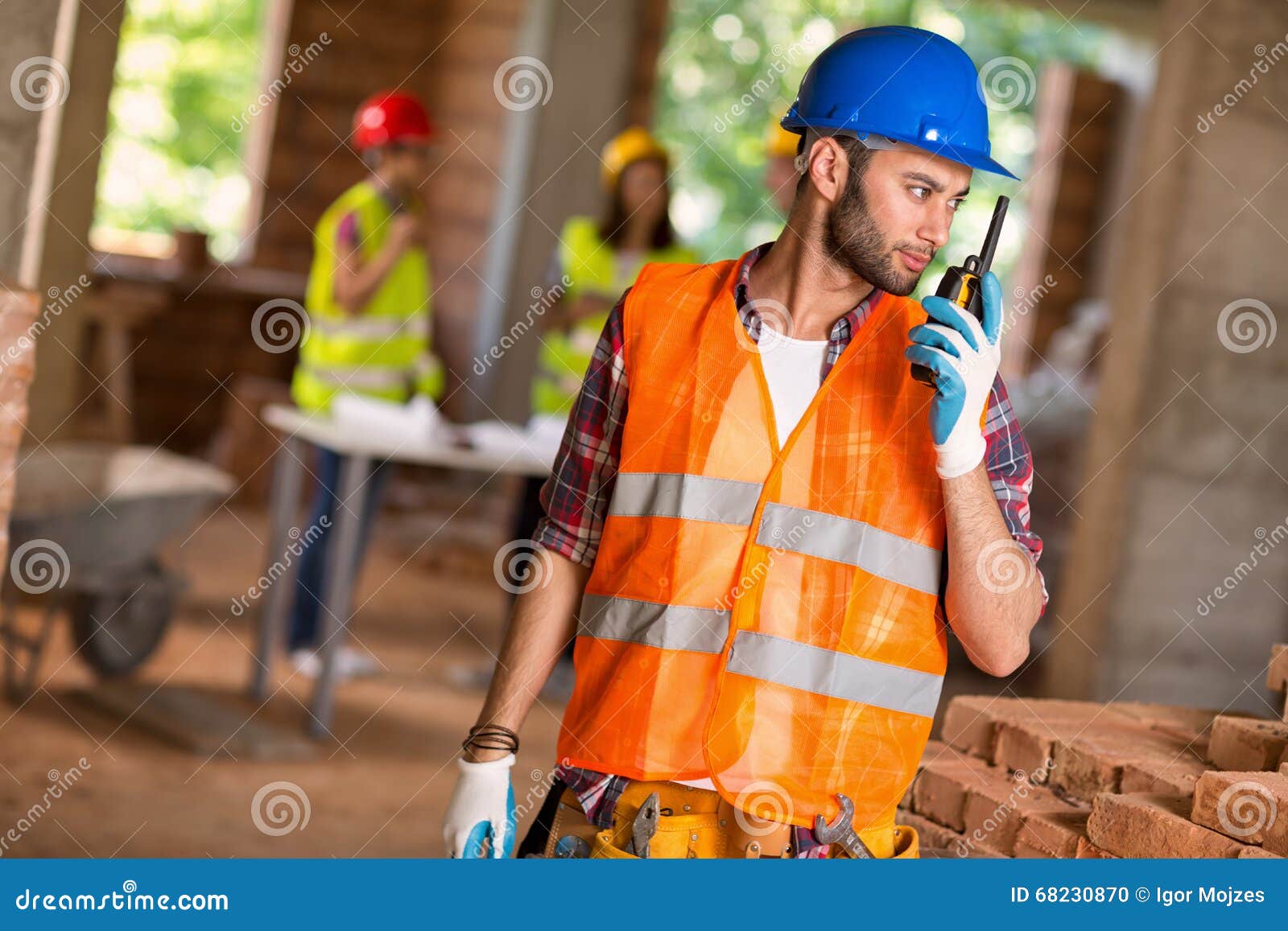 construction worker talking on walkie talkie at site
