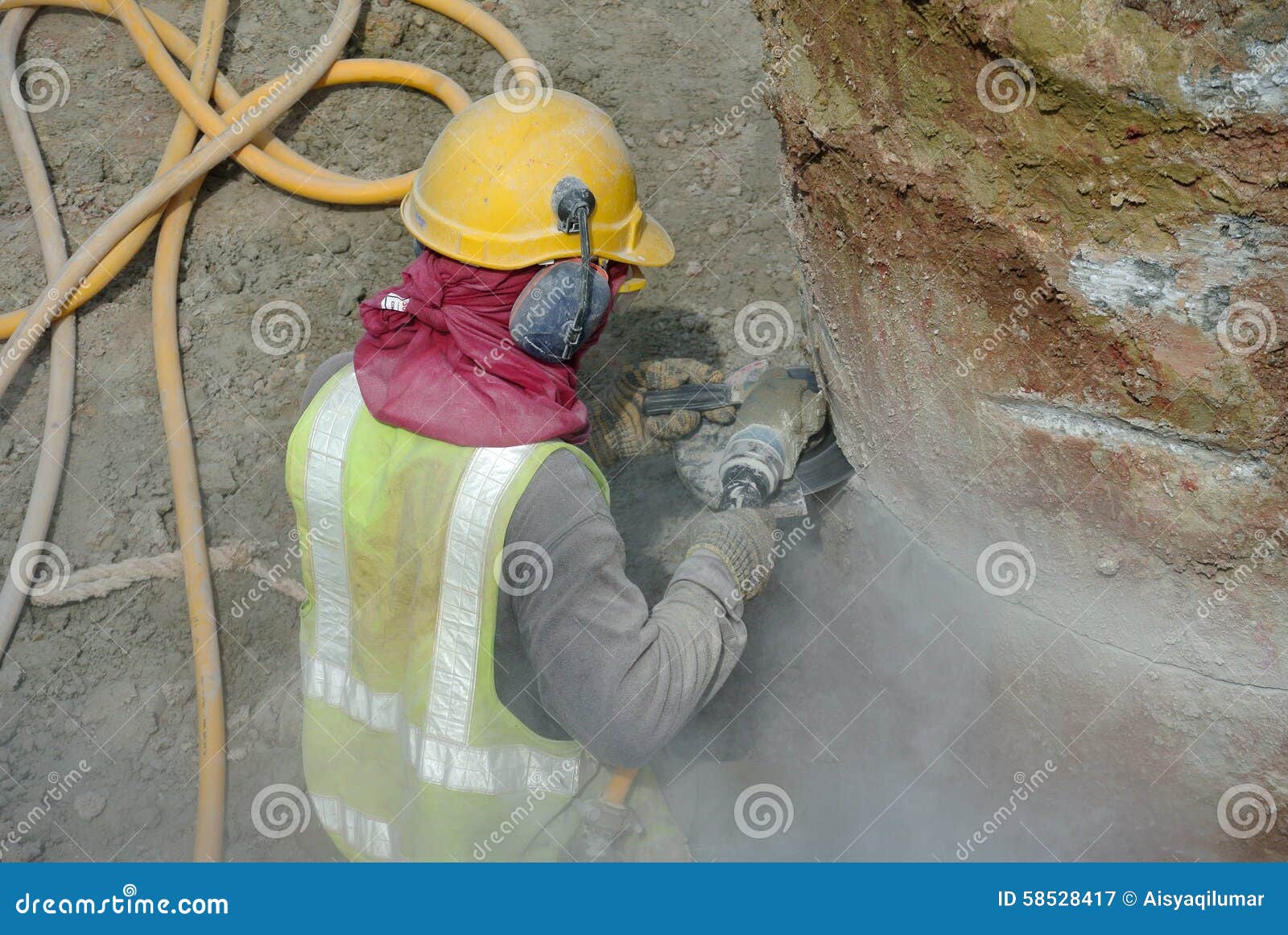 Construction Worker Using Construction Grinder To Cut Concrete Pile