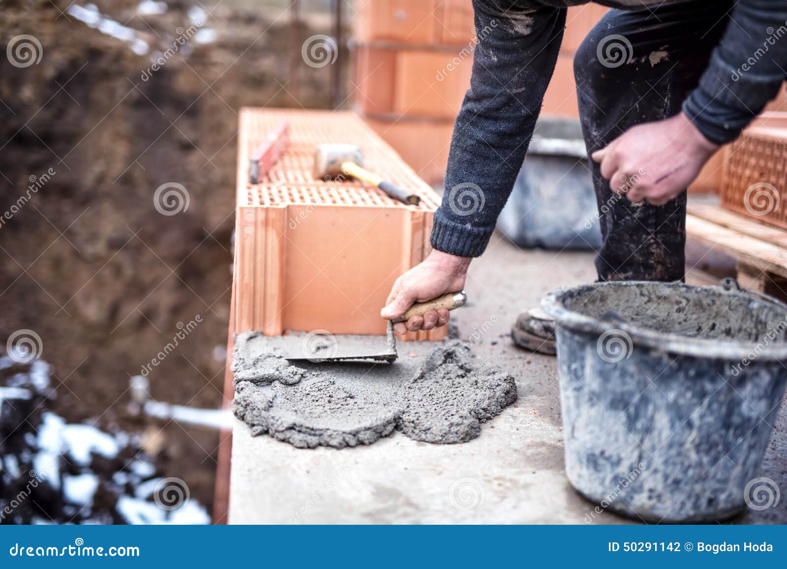 Construction Worker Using Trowel and Cement for Installing the