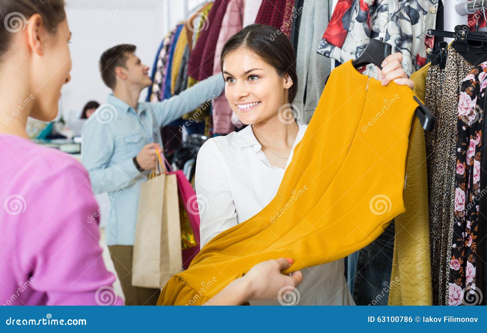 The shop assistant helped me. Продавец одежды. Девушка продавец консультант одежды. Демонстрировать вещи. Продавец предлагает товар.