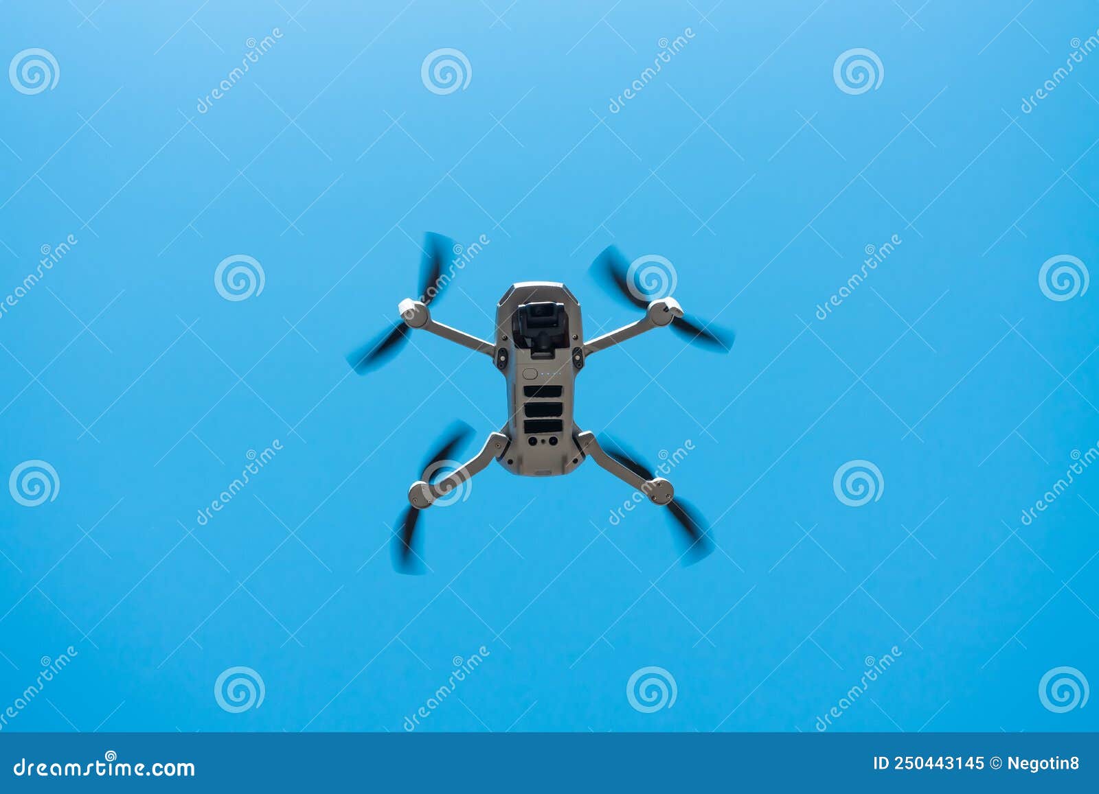 Consumer Drone with Camera Hovering Against Blue Sky Stock Image