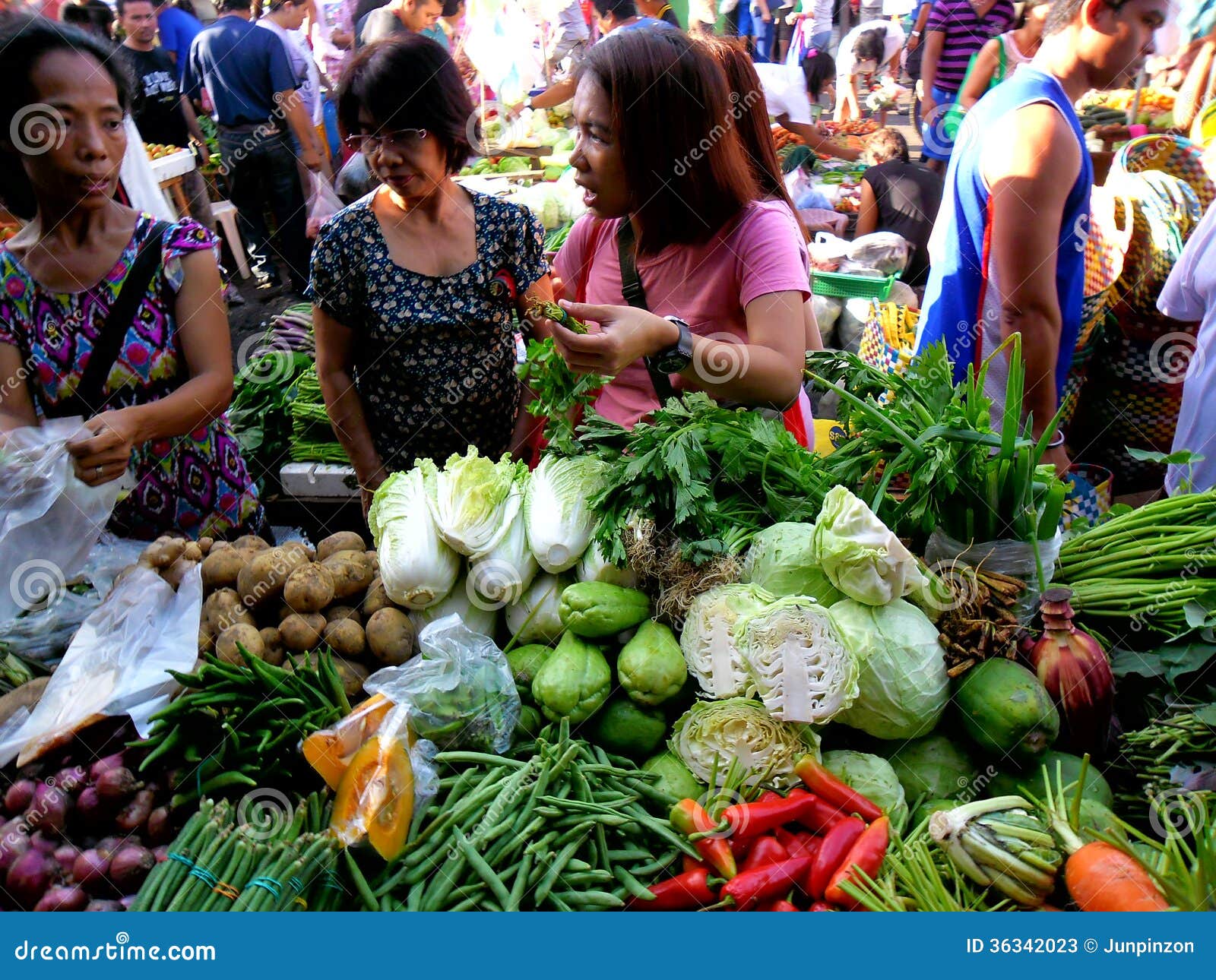 Consumers Buy From A Vegetable Vendor In A Market In ...