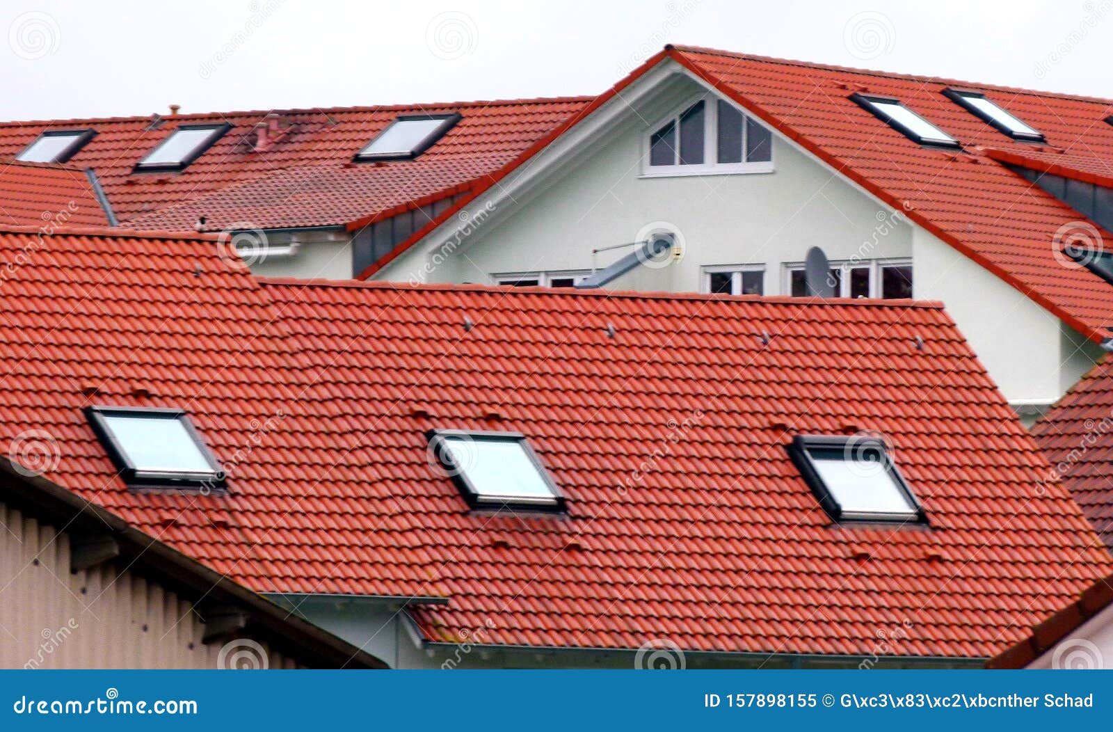 modern residential buildings with natural red tiled roofs and skylights