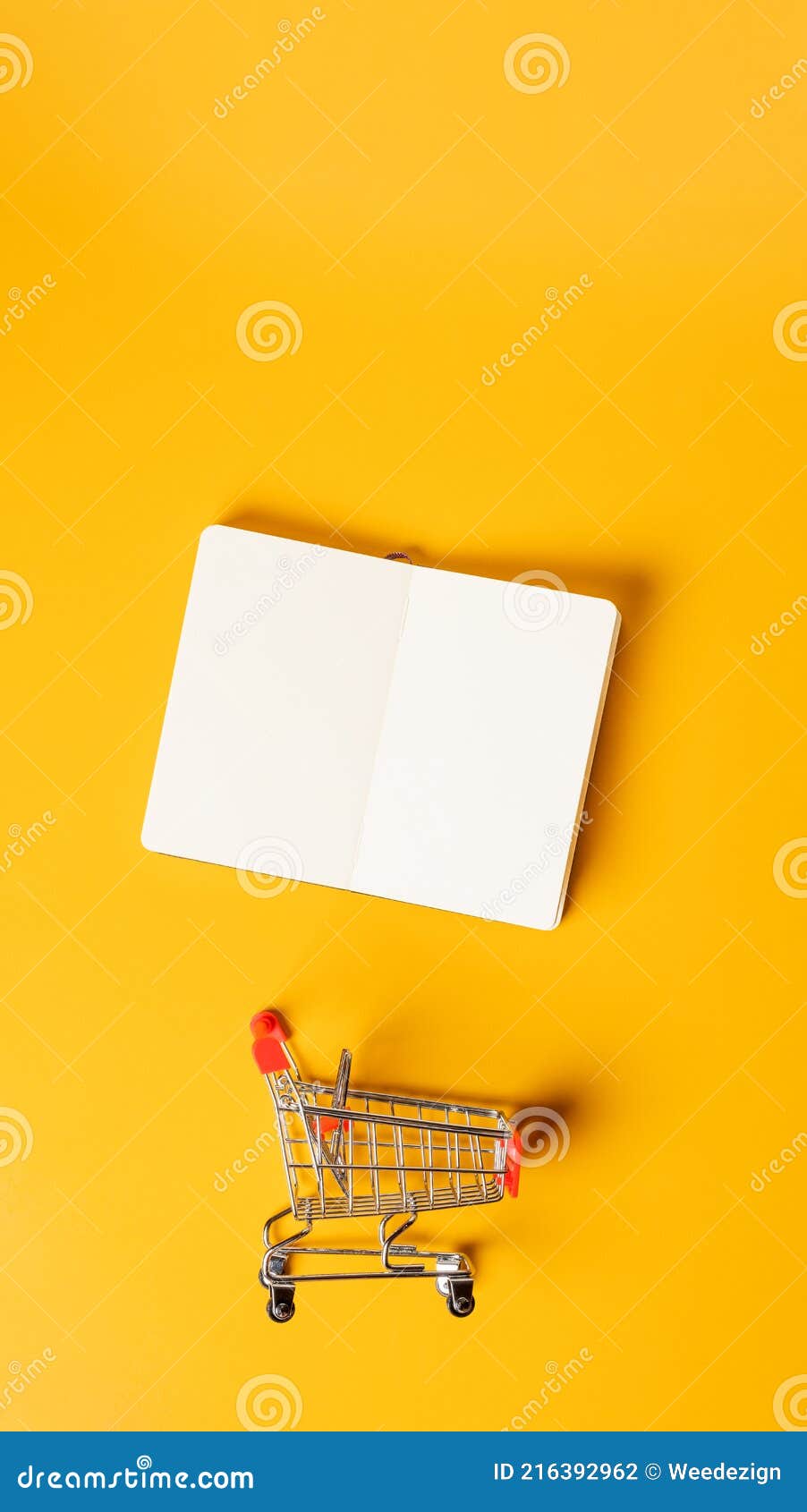 content marketing concept,top view oepn book with shopping cart on yellow desk surface.leave space for display your content.