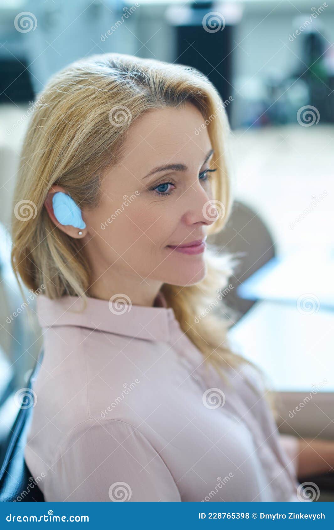 contented female patient wearing a silicone earmold for hearing protection