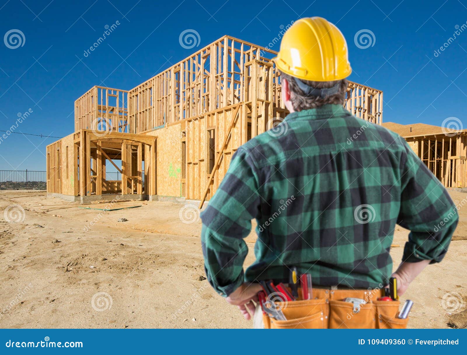 Contractor with Hard Hat at New House Framing at Construction Site