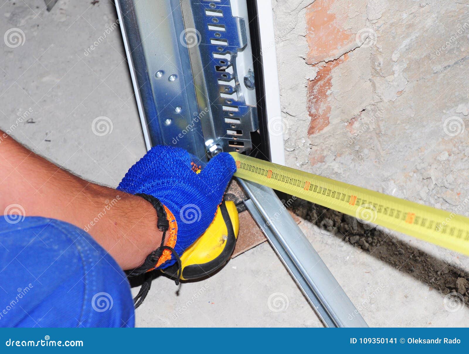 Contractor Installing Garage Door and with Measuring Tape Stock Image