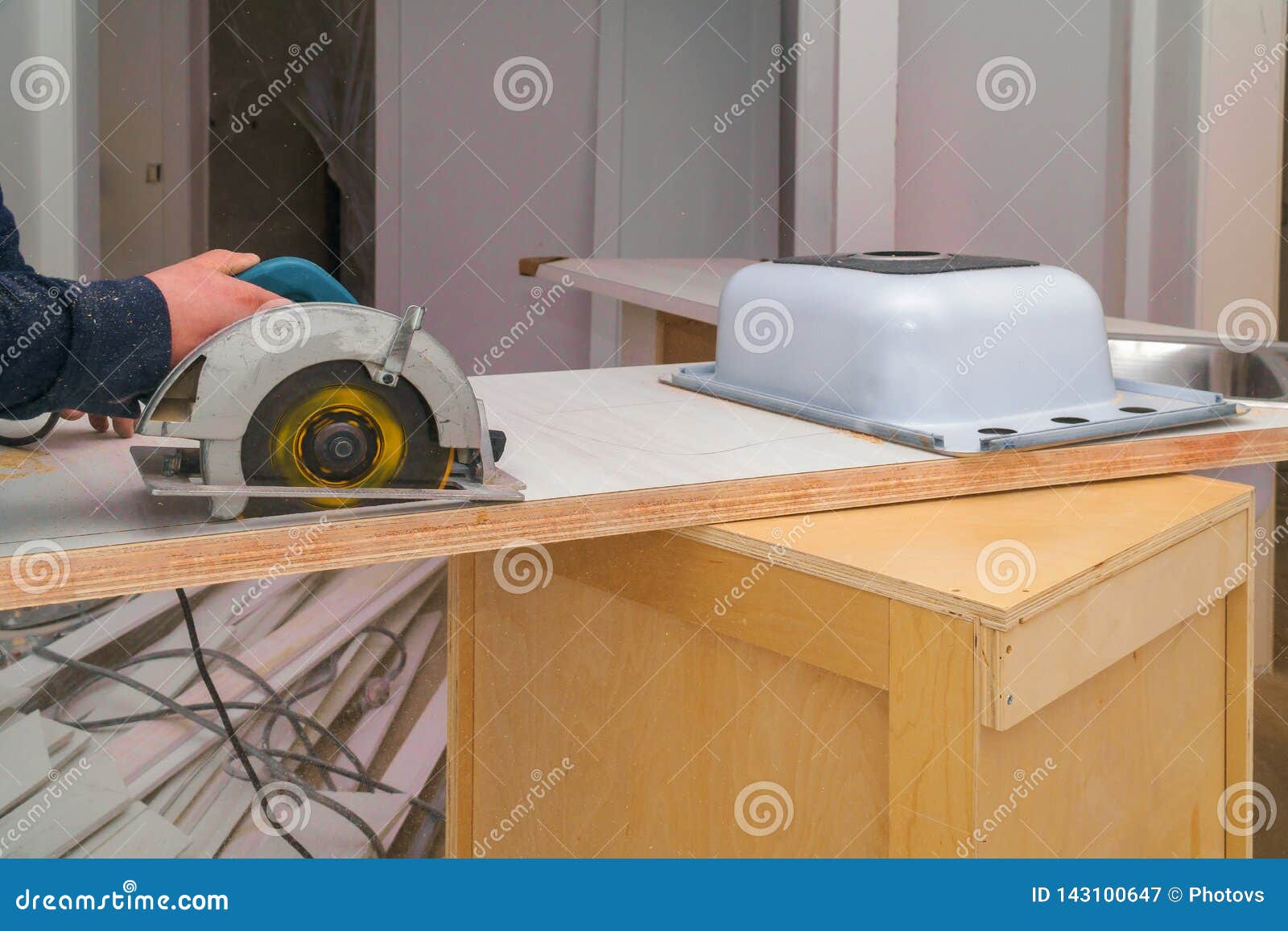 contractor installing sink cut hole laminate counter top carpenter installing remodeling cut hole laminate counter 143100647