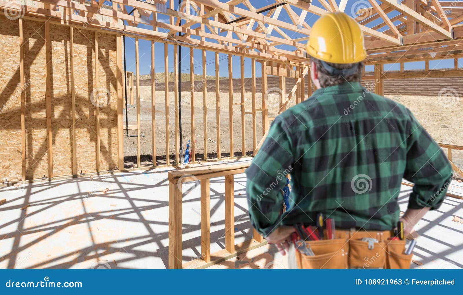 Contractor Standing Inside Construction Framing of New House. Stock