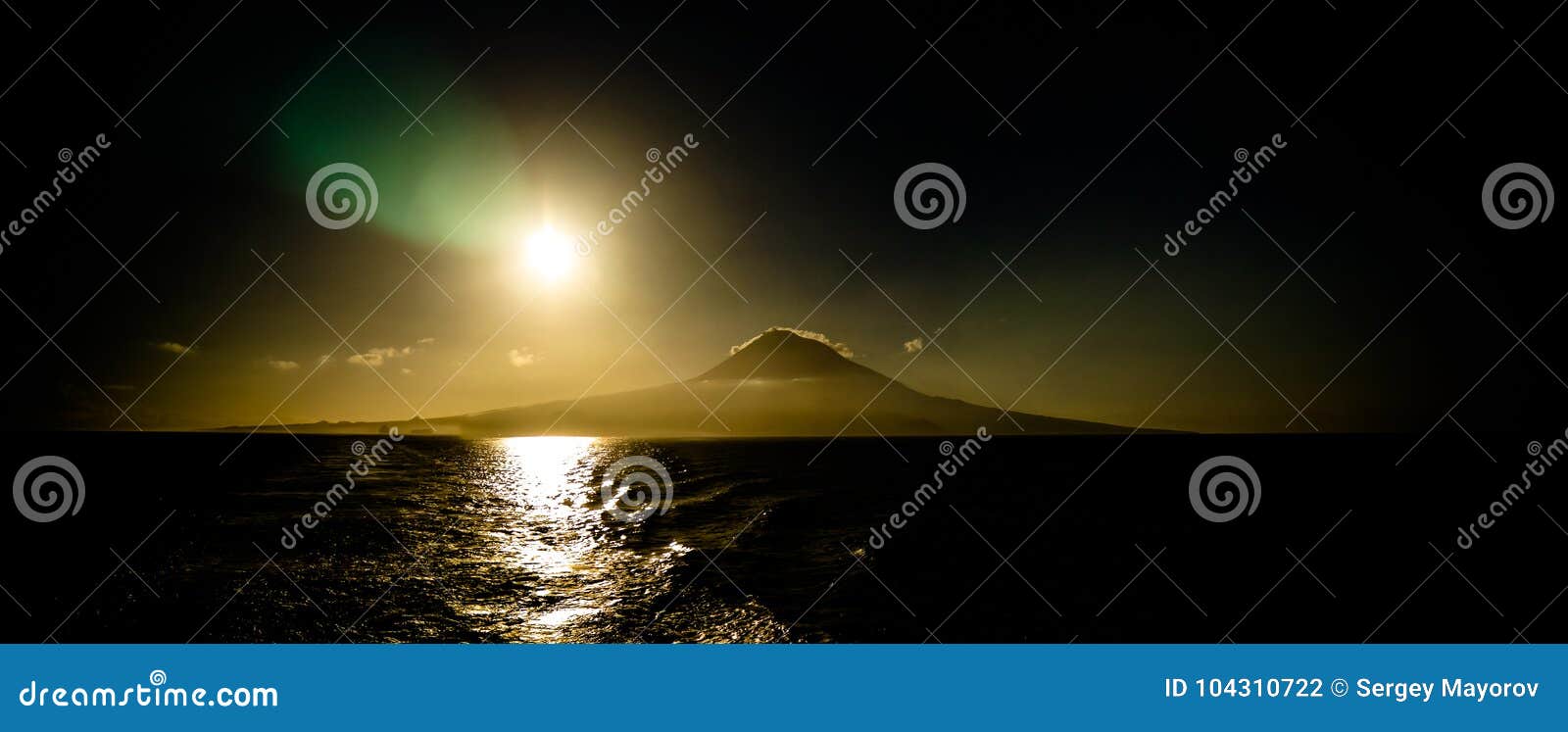 contre jour view to sunrise over pico volcano and island, azores, portugal