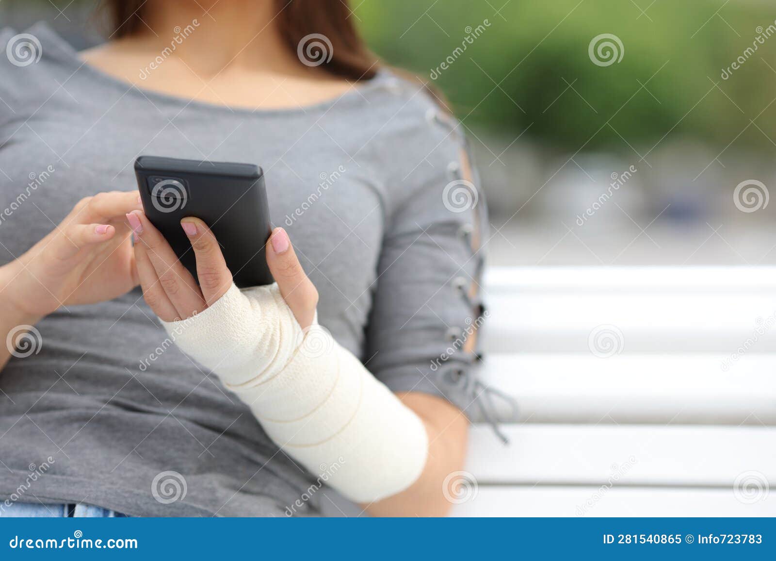 convalescent woman with bandaged arm using phone