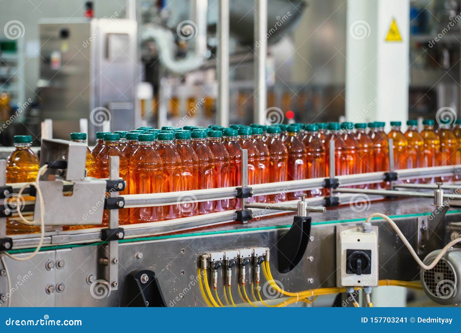 conveyor line with plastic bottles of juice at modern factory equipment. beverage manufacturing plant interior inside