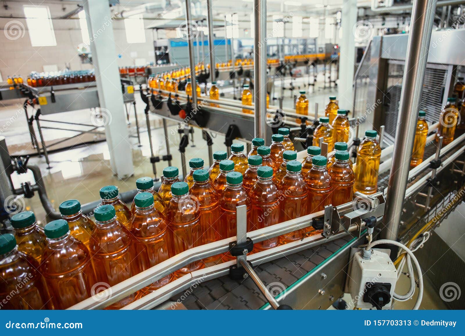 conveyor line with plastic bottles of juice at modern factory equipment. beverage manufacturing plant interior inside