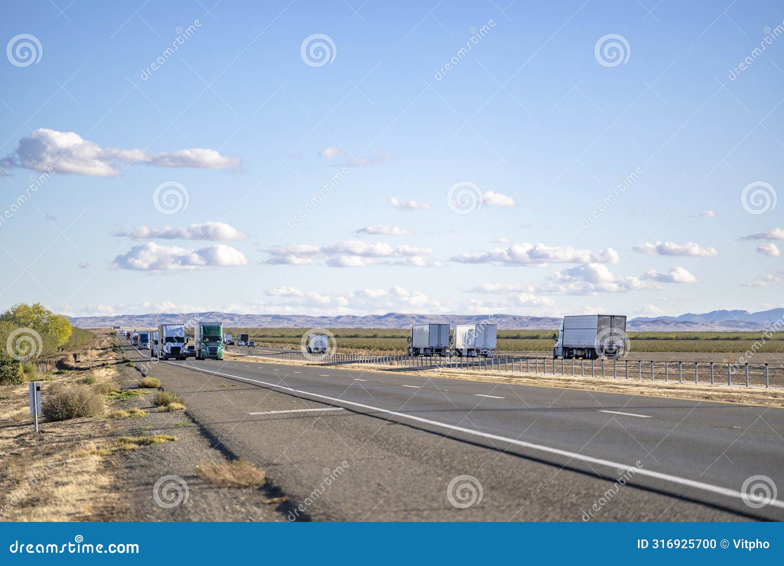 convoy of the big rig semi trucks with semi trailers transporting cargo running in both directions