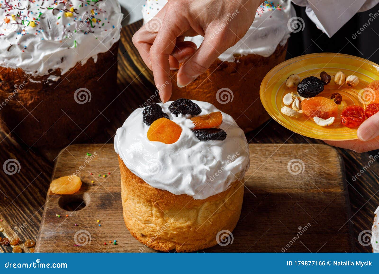cook decorates easter cake with dried fruits
