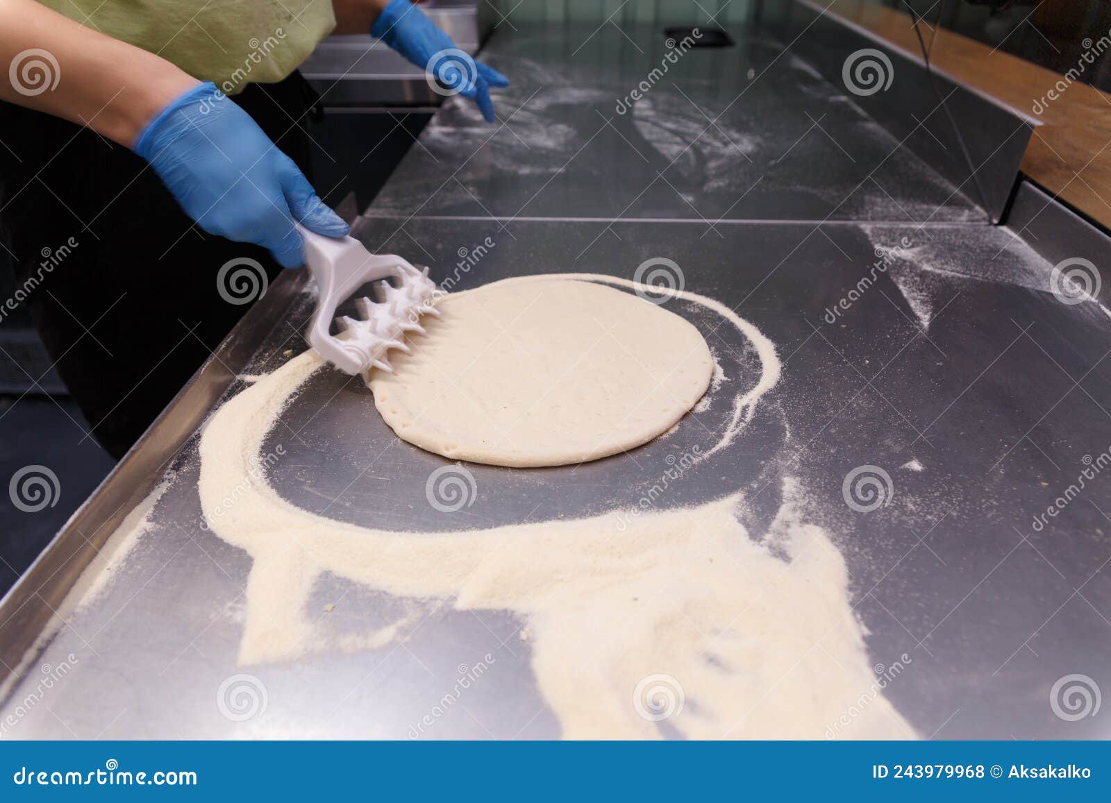 The Cook Processes the Pizza Dough with a Special Roller with Spikes